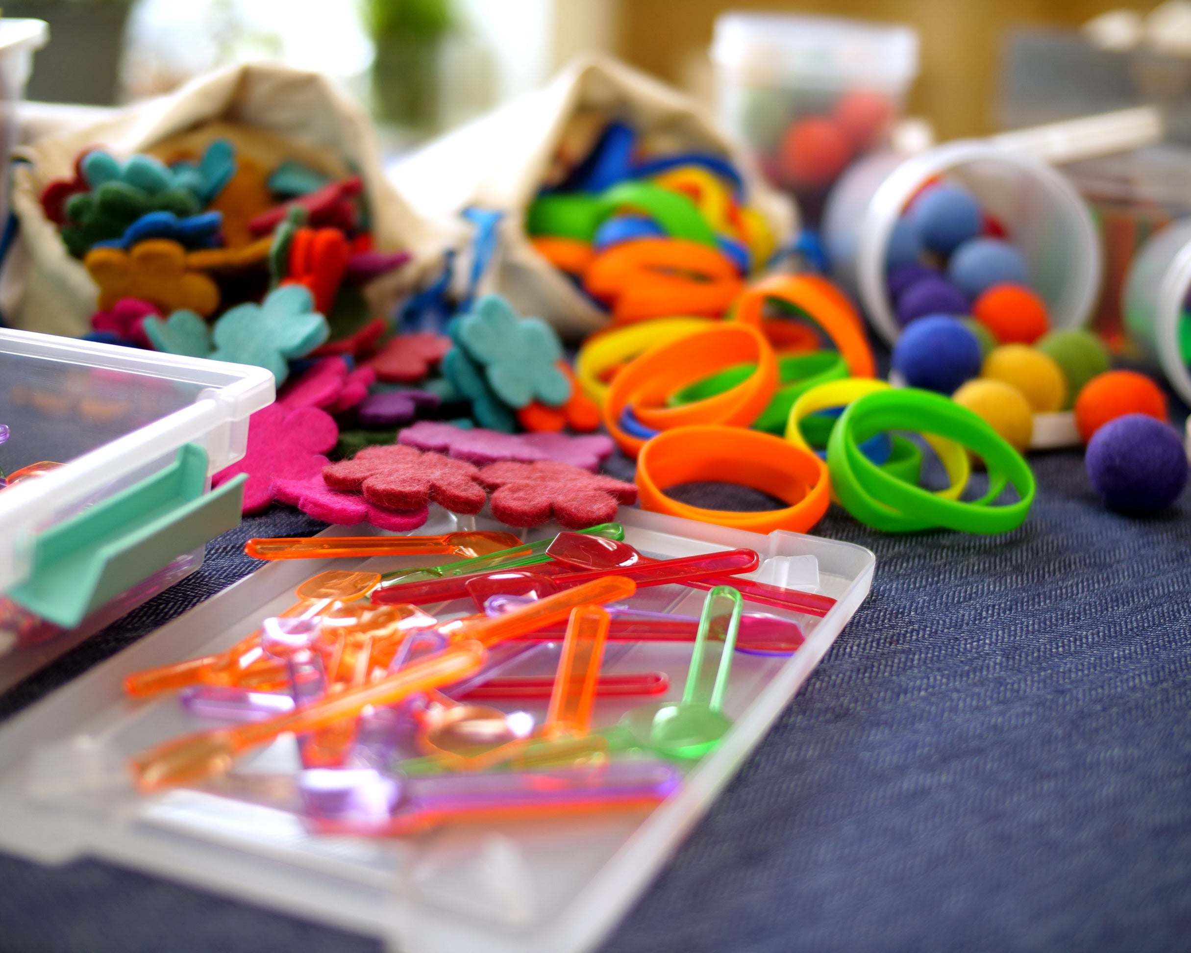 Colorful Loose Parts Color Mix set with translucent pegs, soft silks, and felted wool pieces for creative play and building.