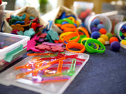 Loose Parts Color Mix set with over 290 colorful textured pieces including translucent pegs, play silks, and felted wool for creative children's play