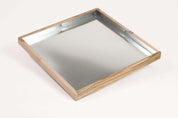 Square activity tray with a light maple wood frame and a reflective steel interior base for sensory play.