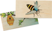 Two wooden matching tiles featuring a detailed bee illustration and a beehive habitat on a branch.
