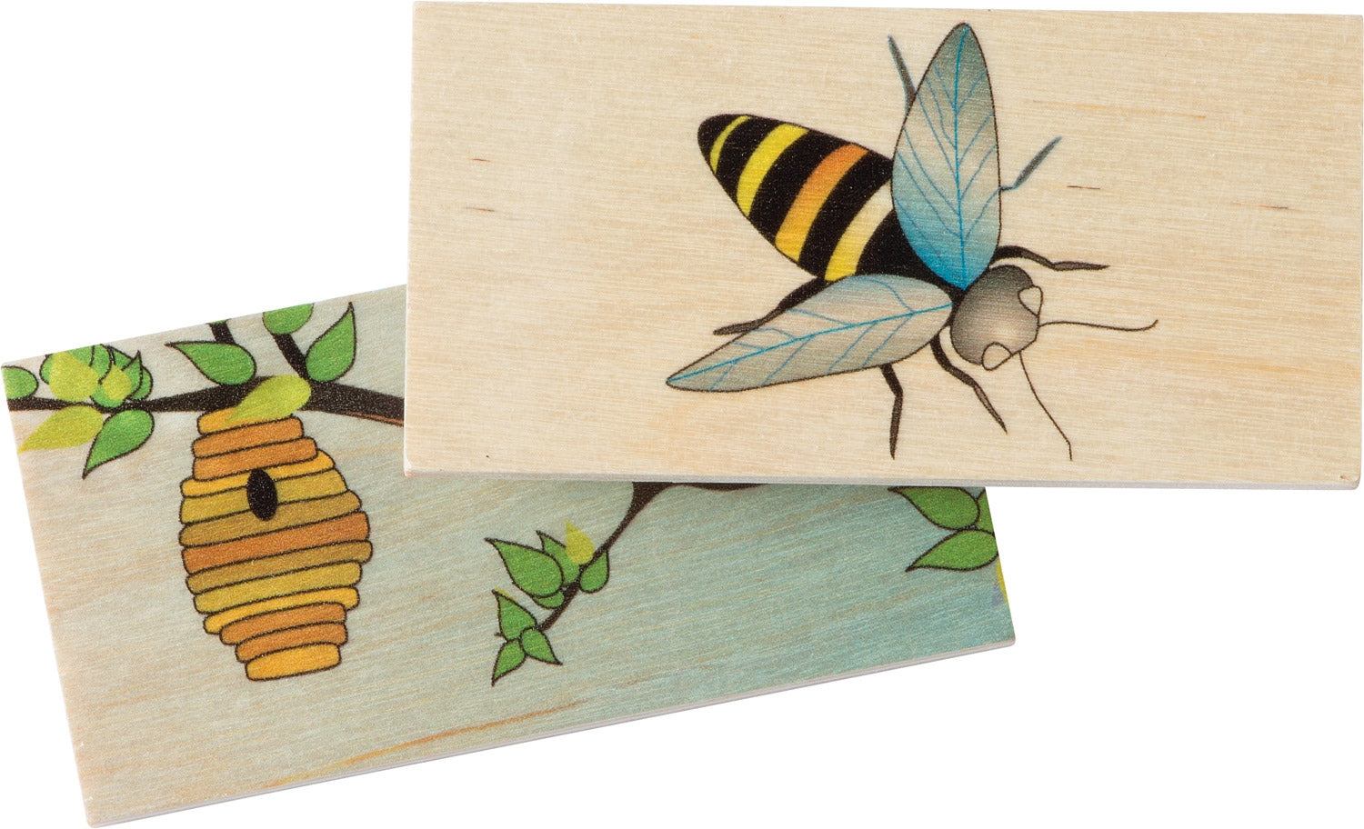 Two wooden matching tiles featuring a detailed bee illustration and a beehive habitat on a branch.