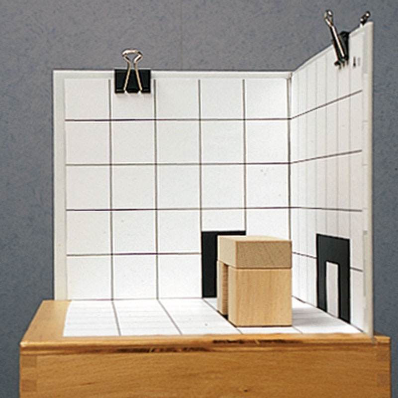 Wooden building blocks on a white grid base with black shadow silhouettes, set against a matching grid backdrop.
