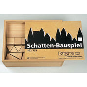 Wooden building block puzzle set in a sliding lid box with a black silhouette skyline design on the cover.