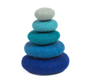 Stack of five smooth, felted wool stones in a gradient of blue shades, from light grey-blue to deep navy.