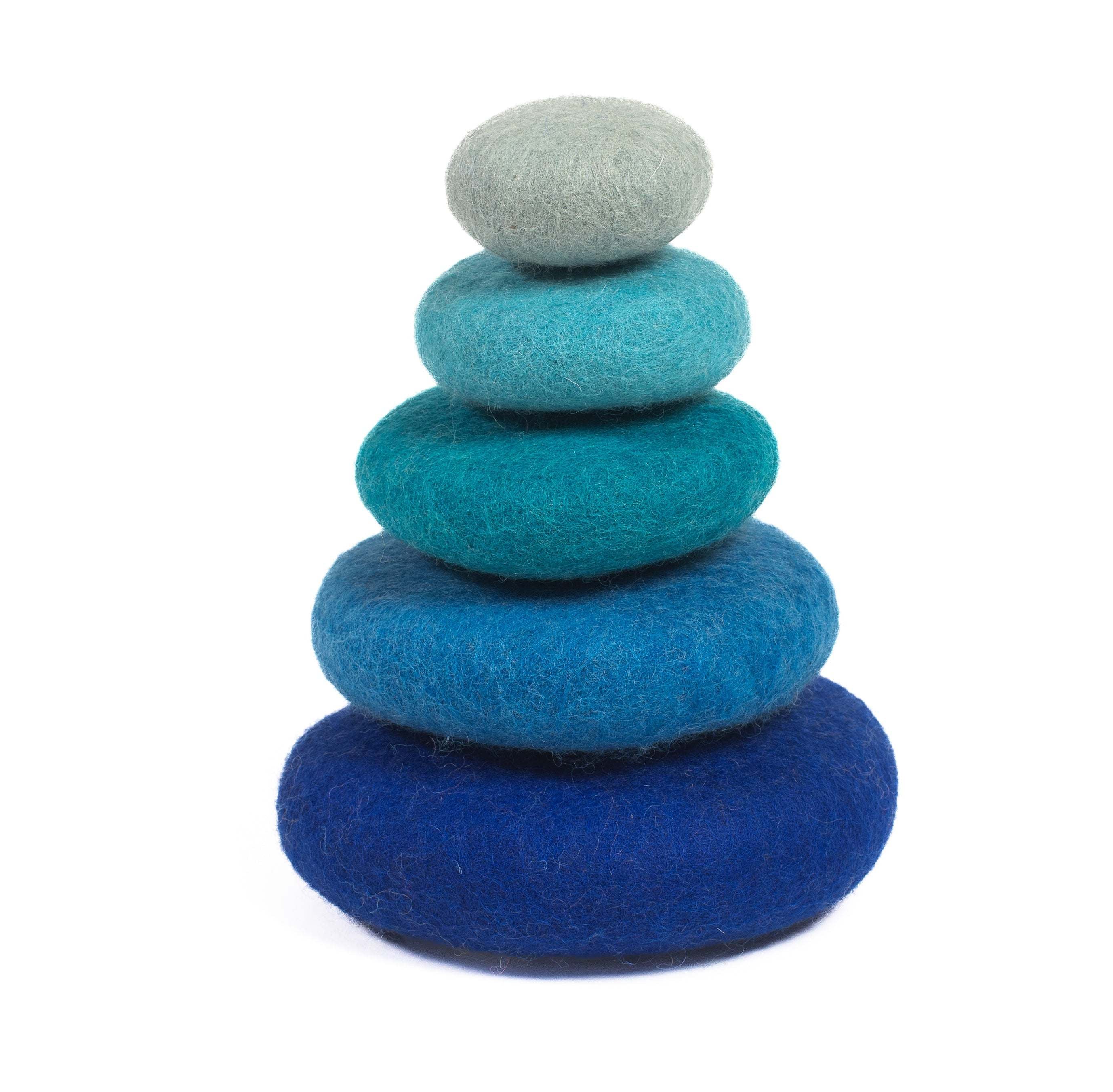 Stack of five smooth, felted wool stones in a gradient of blue shades, from light grey-blue to deep navy.
