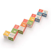 Sixteen colorful wooden math blocks featuring embossed numbers, symbols, and Braille cells arranged in a zigzag line.
