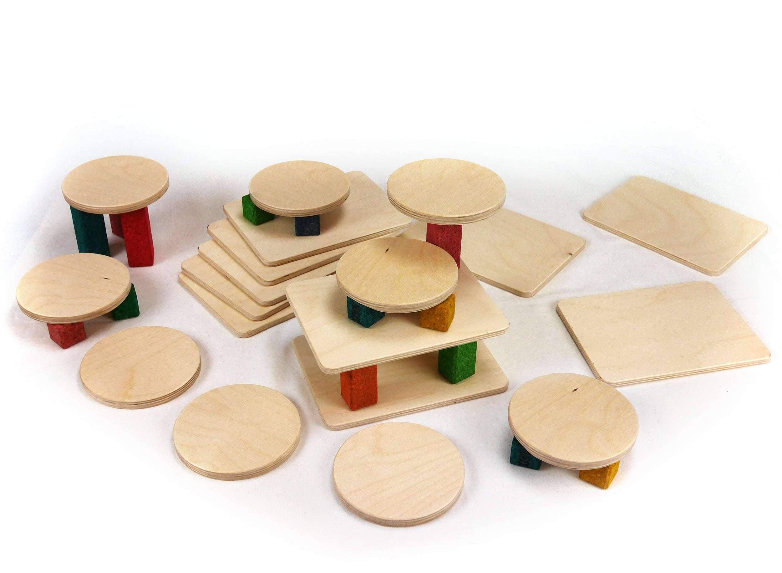 Set of ten natural wood building boards and circular platforms supported by colorful wooden blocks on a white background.