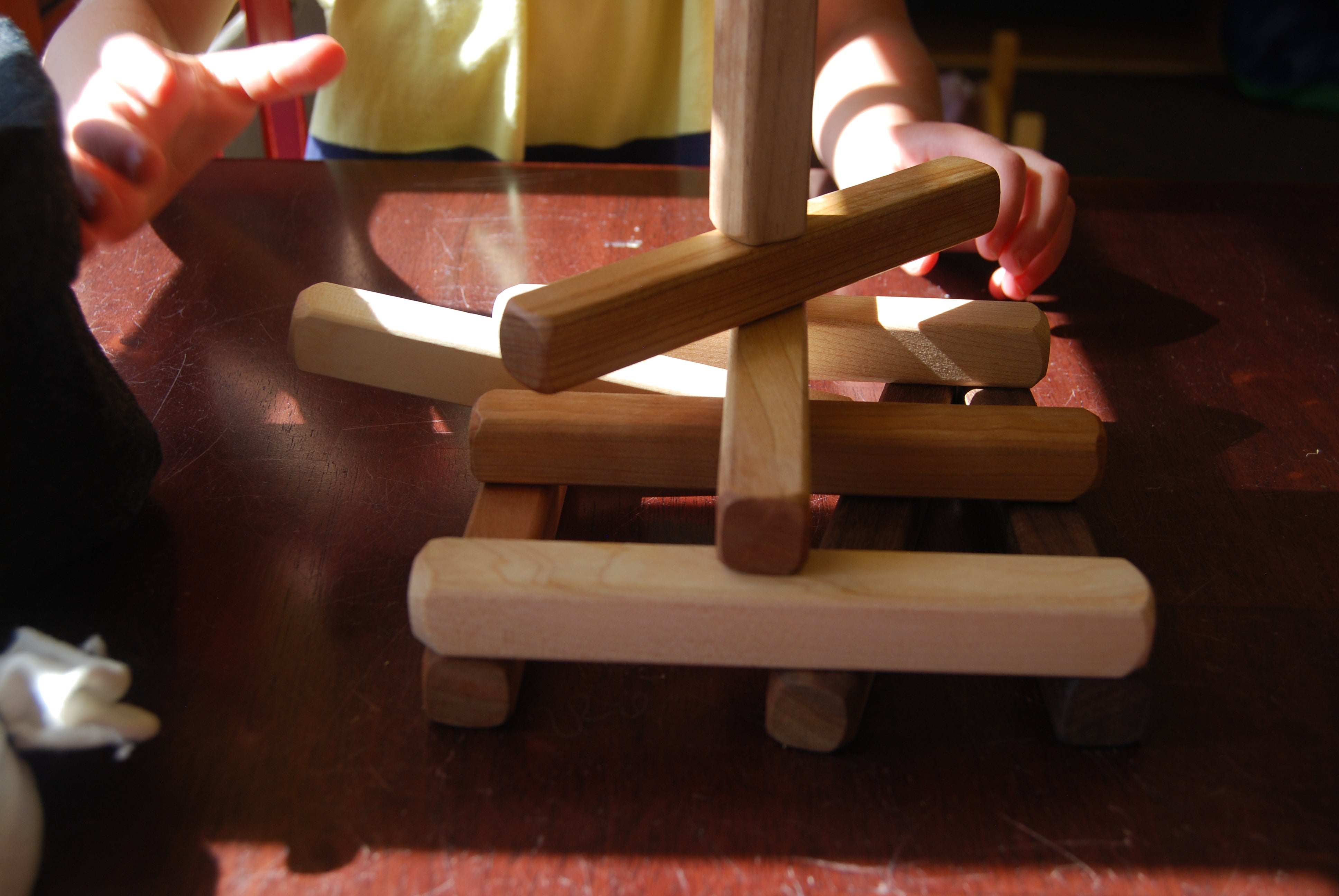 Set of 18 building sticks in cherry, maple, and walnut with rounded edges for stacking and building