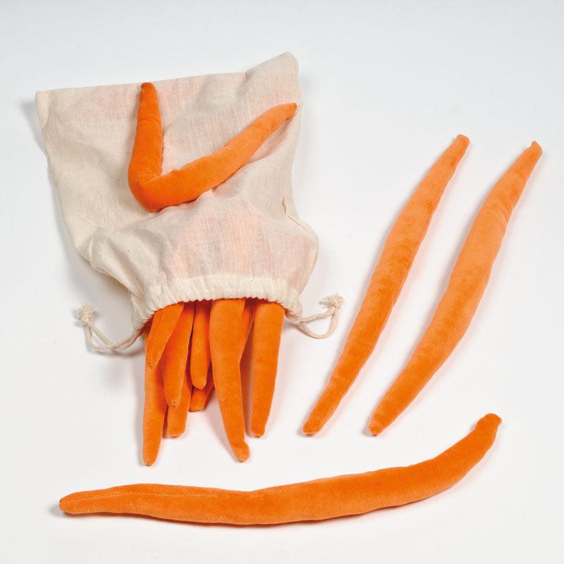 Soft orange fabric sensory tails spilling from a cream-colored cotton drawstring storage bag.
