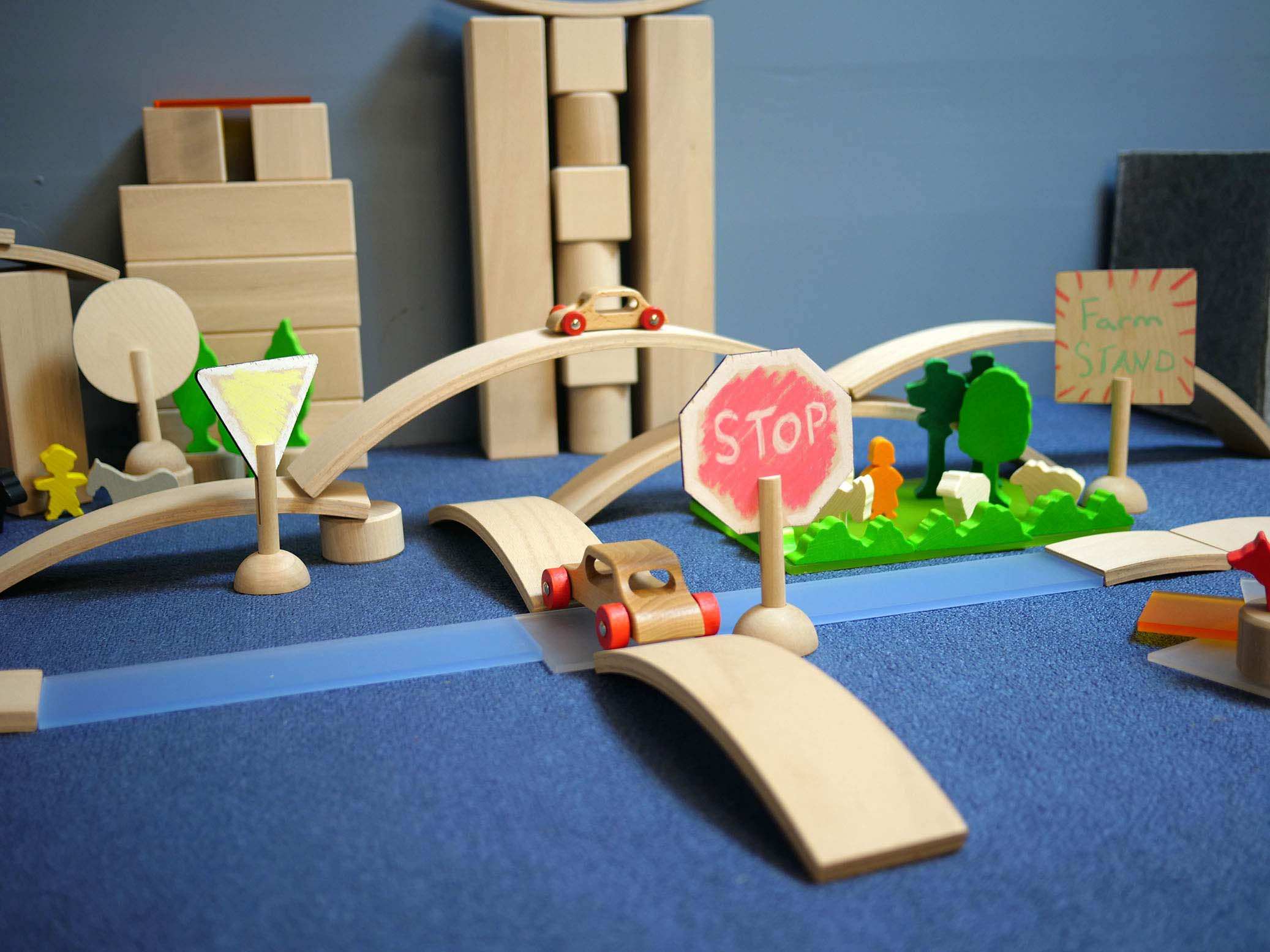 Wooden sign-making set with hand-painted stop and yield signs displayed in a creative wooden block landscape.