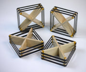 Four square wooden deflectors with cross-shaped centers and black elastic bands on a white background.