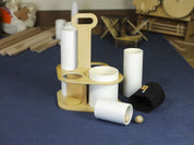 Wooden caddy with white tubes, a black canvas storage pouch, and a small wooden ball on a blue carpet.