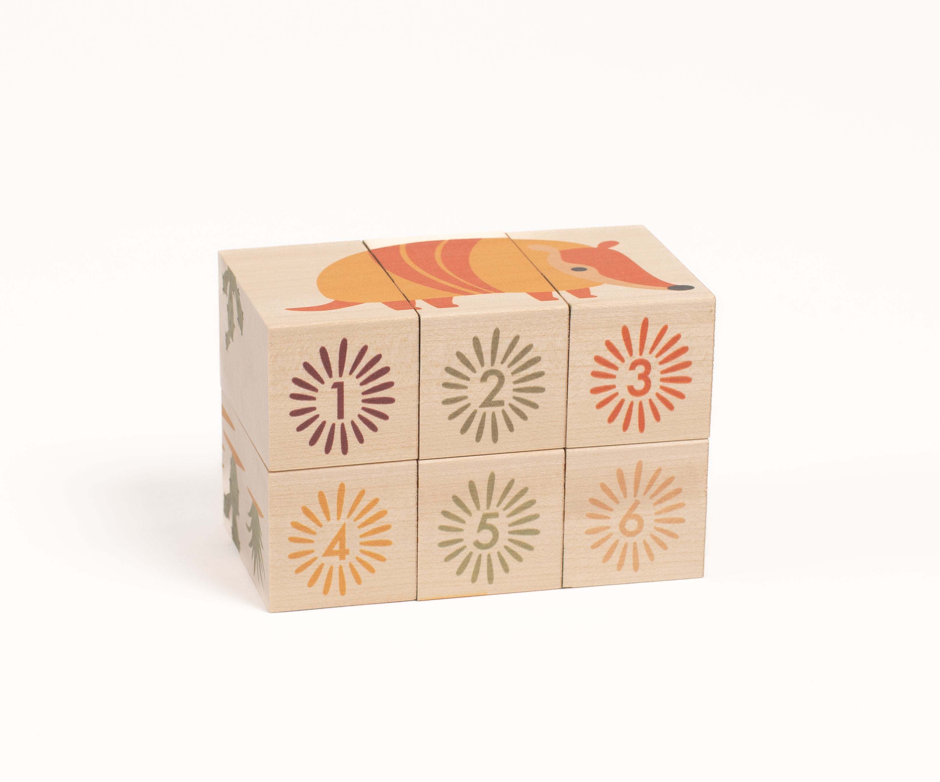 Sustainable basswood blocks featuring an armadillo illustration and numbered sunburst designs in desert colors.