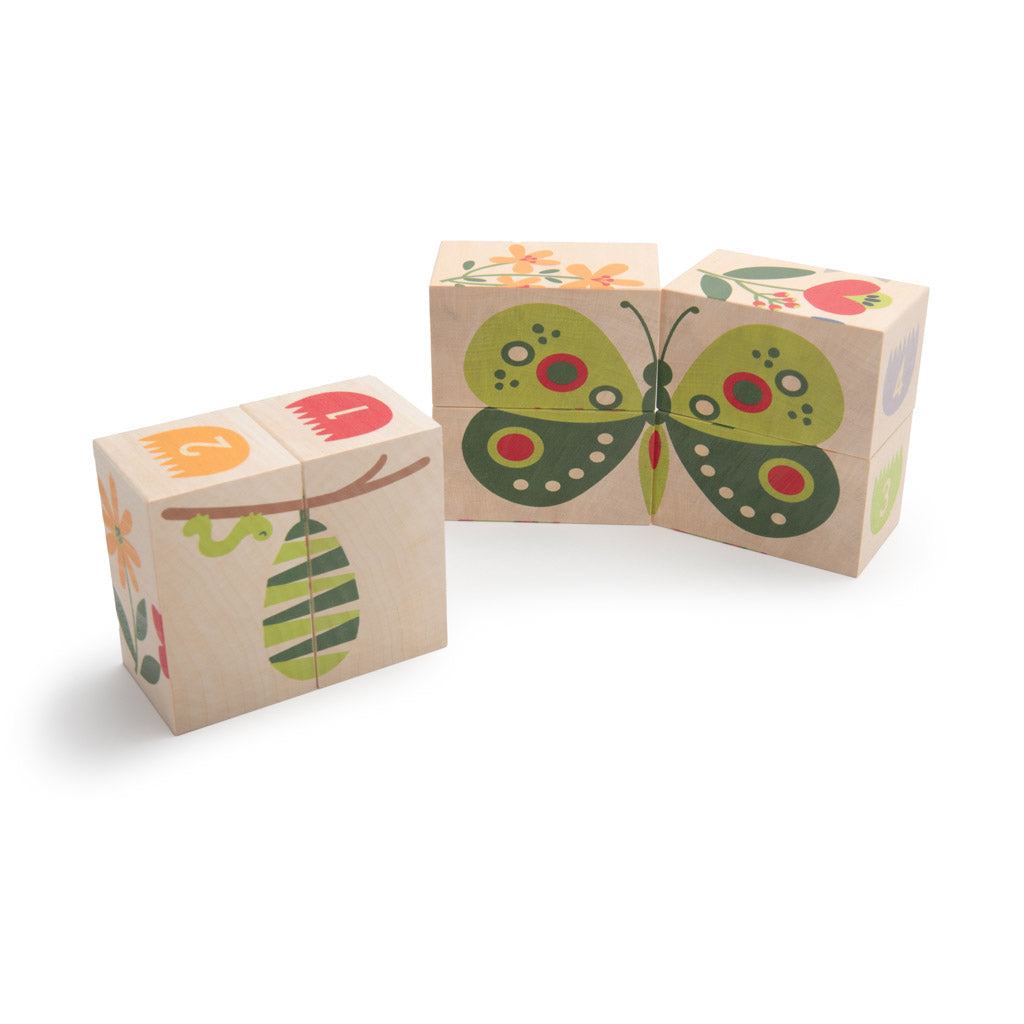 Six wooden blocks featuring colorful garden illustrations of a butterfly, chrysalis, flowers, and numbers on a white background.
