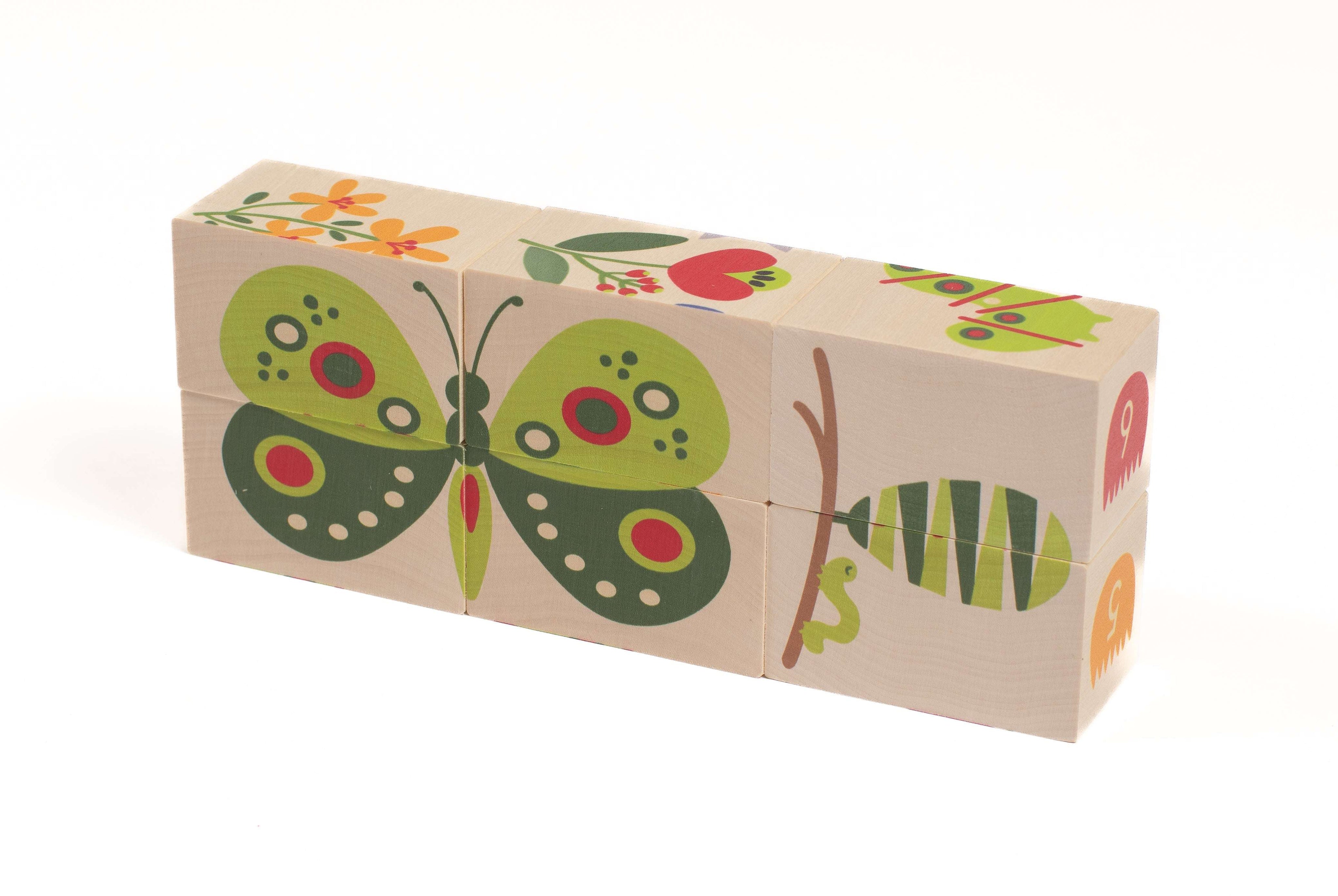 Six wooden blocks featuring colorful garden illustrations of a butterfly, flowers, and a caterpillar on a white background.
