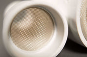 Close-up of white plastic Jurassic Sifter Scoops featuring a fine metal mesh screen for filtering sand.