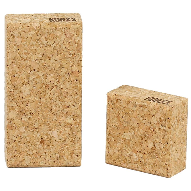 Two rectangular Korxx building blocks made of natural, textured cork with branded logos, isolated on a white background.