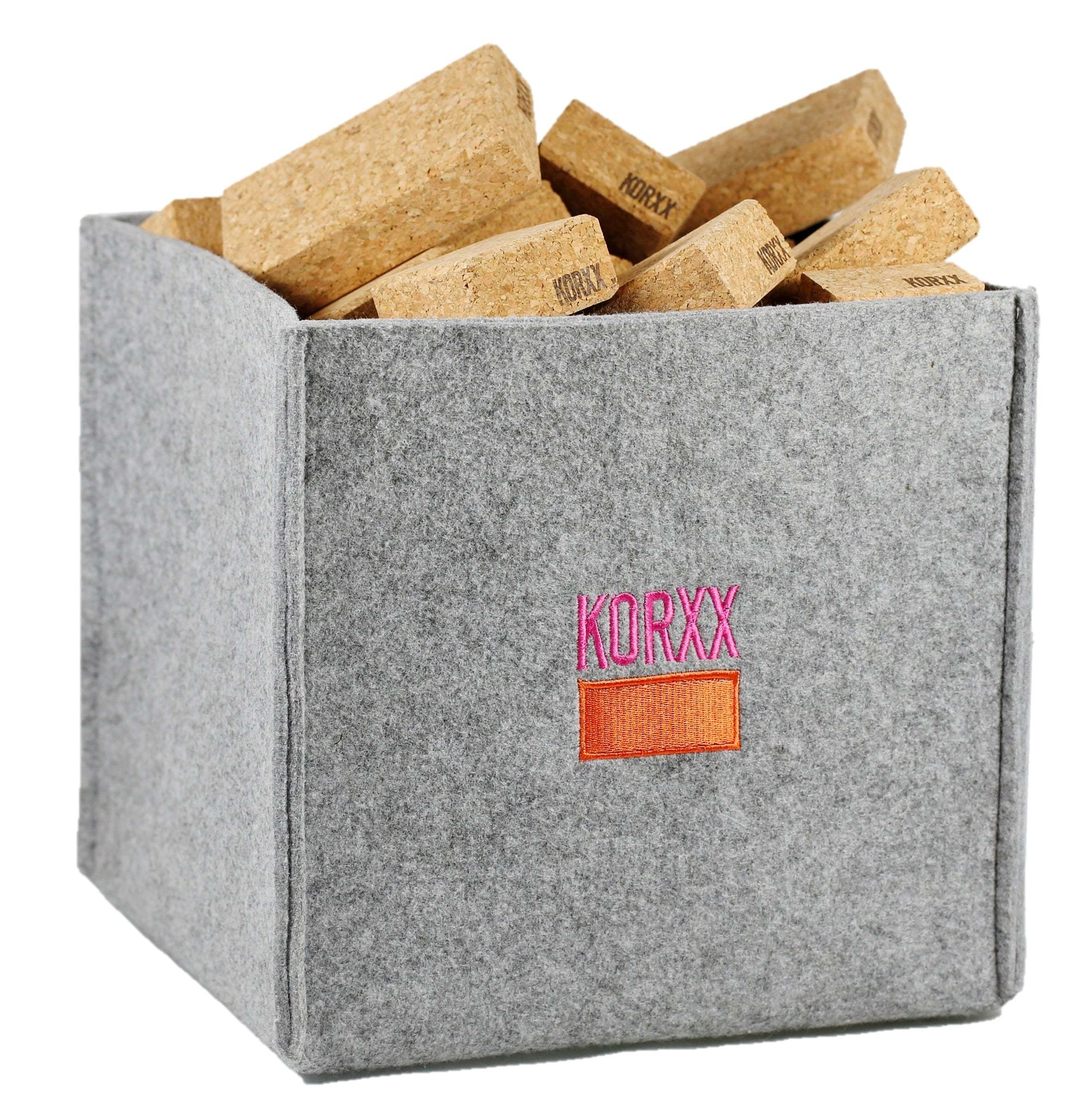 Lightweight cork building blocks stored in a grey felt storage bin with the Korxx logo.