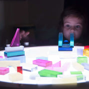 Child using Light Lab Panel with red, green, and blue knobs to mix light colors in classroom setting