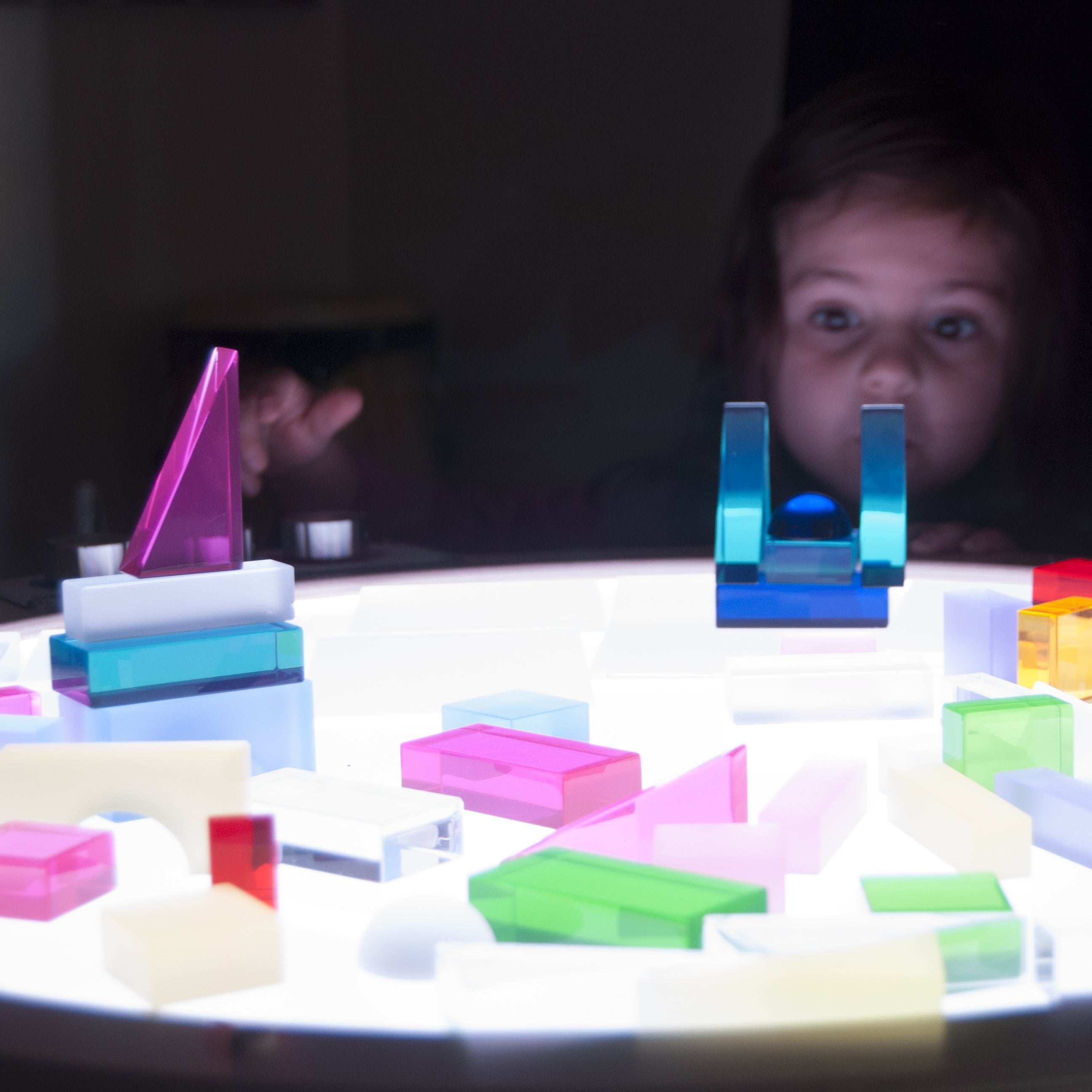 Child using Light Lab Panel with red, green, and blue knobs to mix light colors in classroom setting