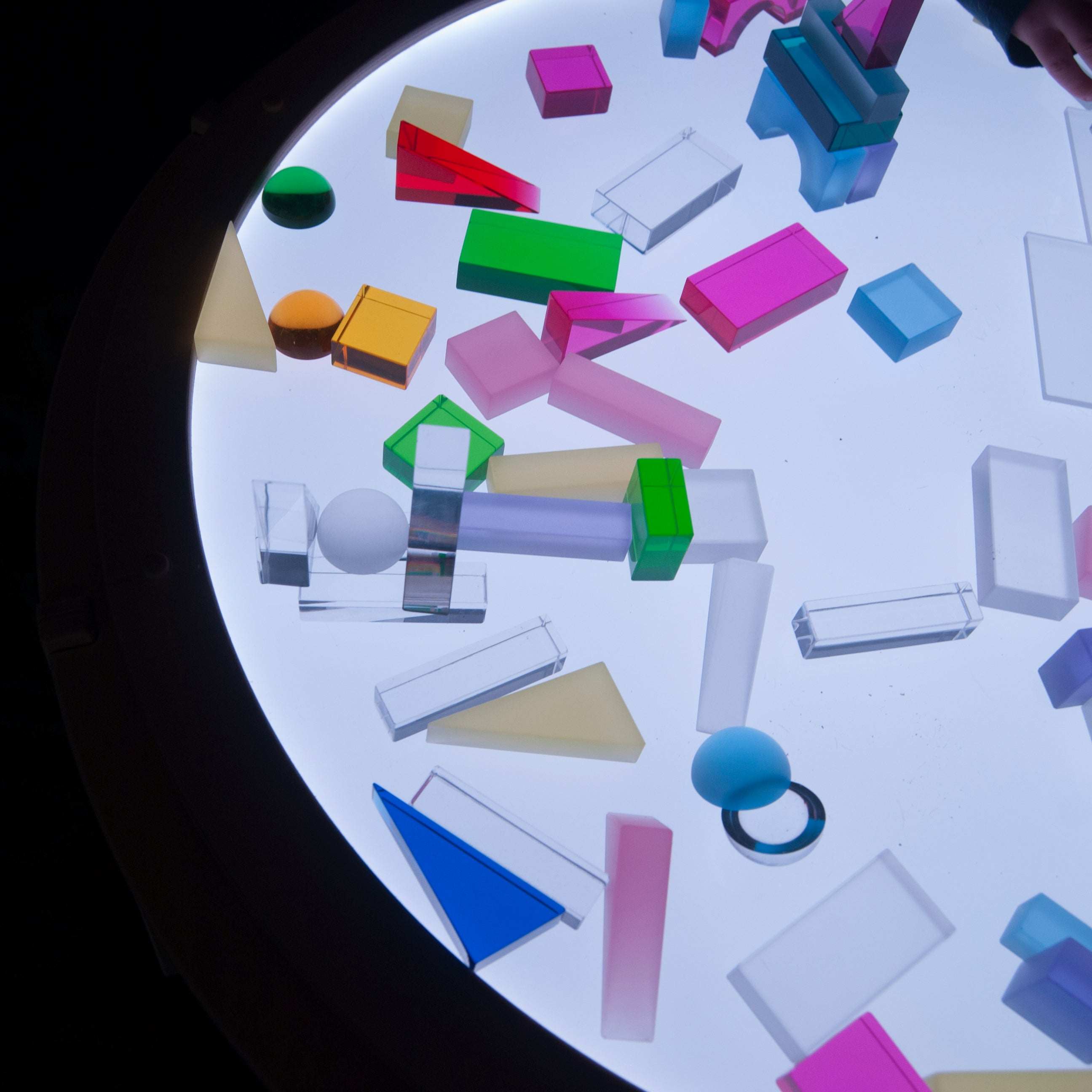 Three clear, protective screen covers for a round Light Lab panel, shown atop a surface with colorful translucent shapes.