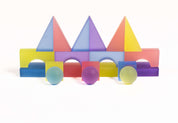 Colorful frosted translucent building blocks in geometric shapes arranged on a white background.