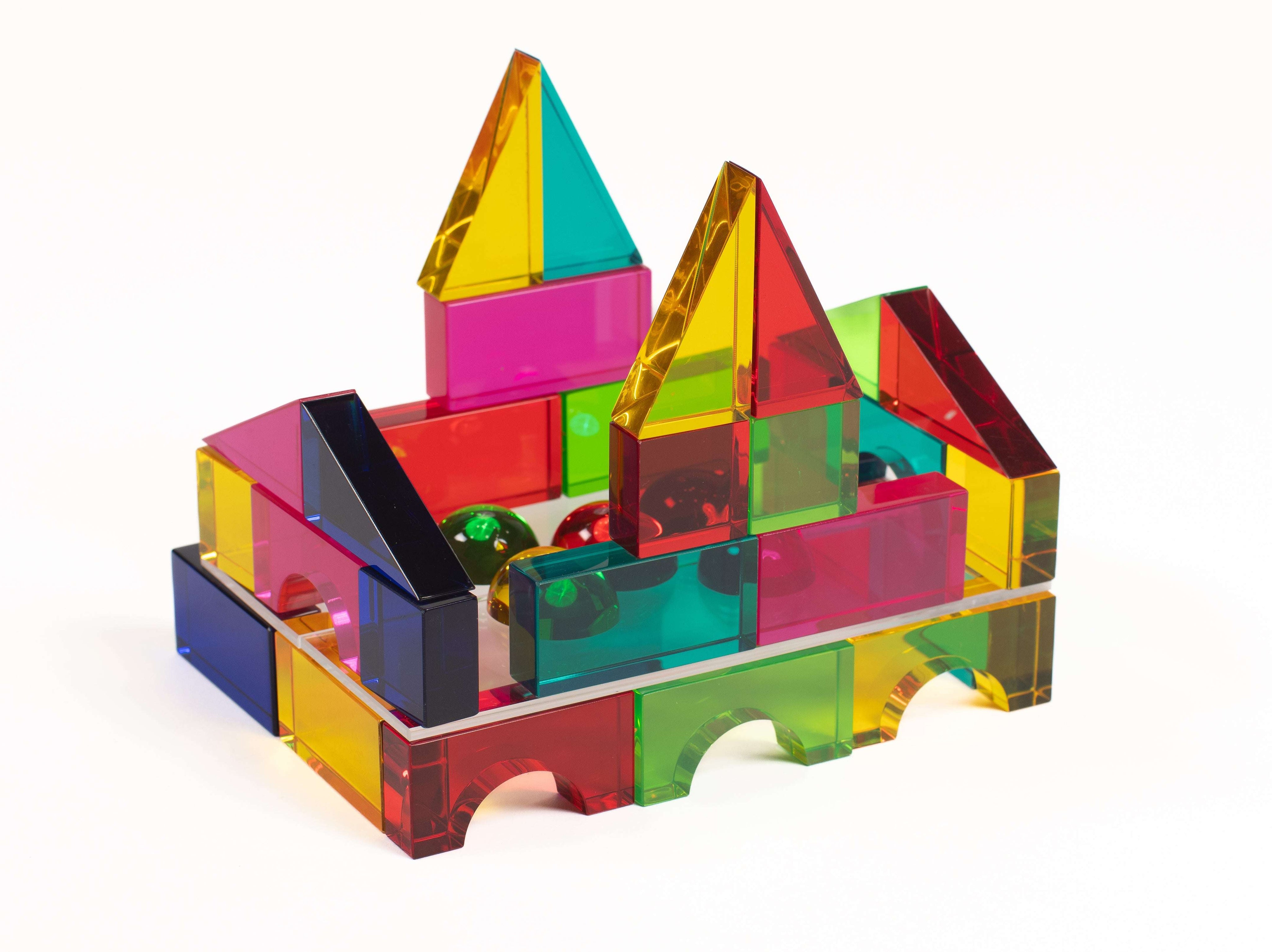 Colorful, transparent Luxi building blocks arranged into a small castle structure with glossy, geometric shapes.