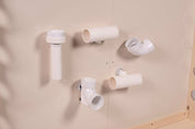 White plastic magnetic chutes and tubes attached to a smooth, light-colored wall for interactive play.