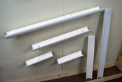White plastic magnetic gutter tracks of various lengths mounted on a wall for educational play.