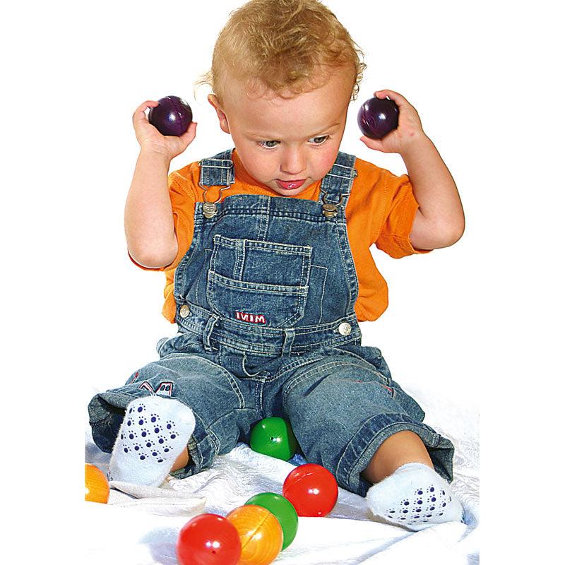 Toddler playing with smooth, colorful Melody Balls for sensory and auditory STEM learning.