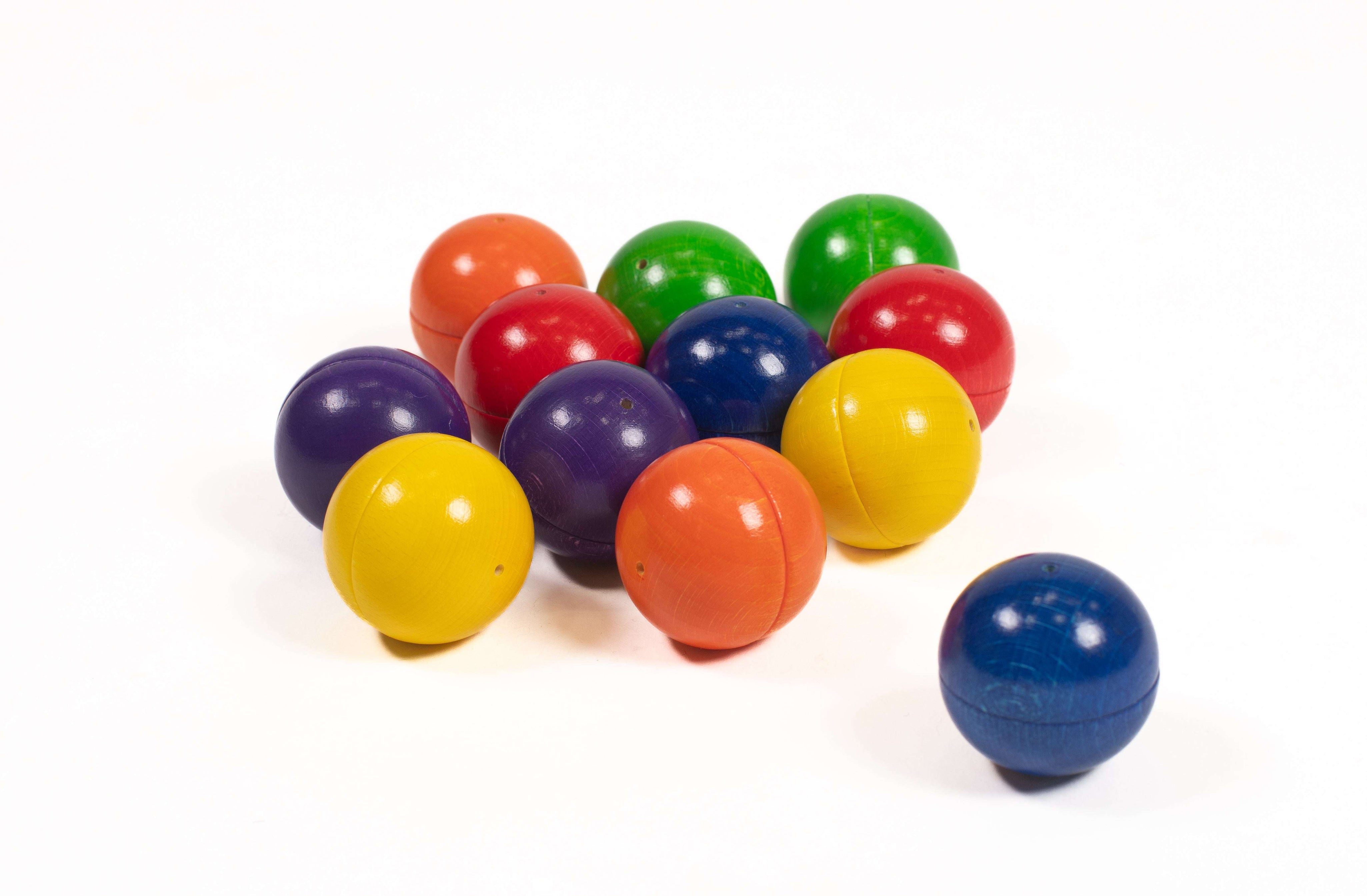 Set of smooth, colorful wooden Melody Balls for sensory play, arranged on a white background.