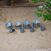 Children using metal pails for outdoor learning activities like digging and sorting