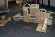Set of 10 hardwood mirror blocks with Mylar mirrored interiors arranged in a structure on a carpeted floor.