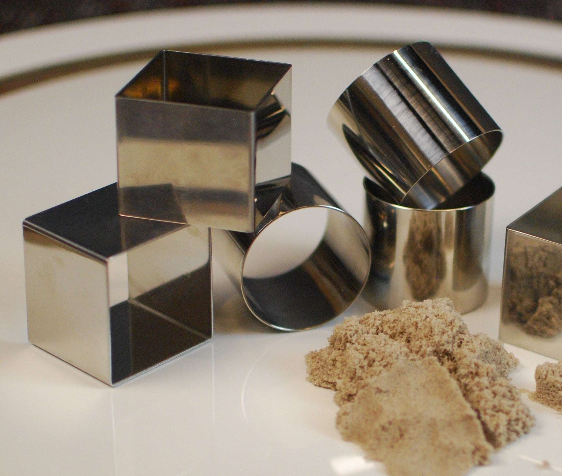 Set of six durable stainless steel square and cylindrical molds for shaping sensory sand or clay.