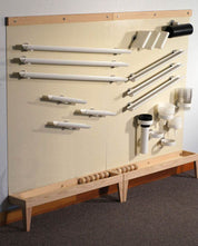 Beige vertical magnetic wall with wooden trim, featuring various white plastic ramps, tubes, and cups for physics experiments.