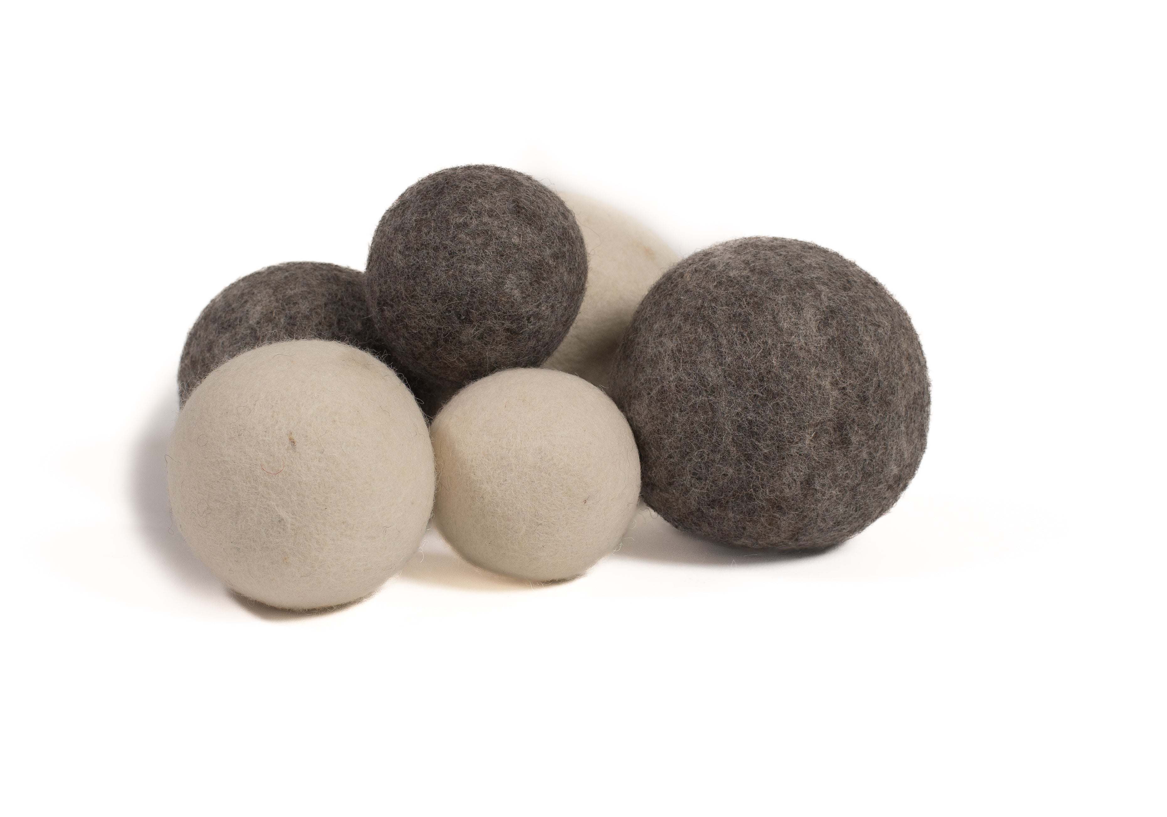 A cluster of soft, round, undyed natural wool balls in varying shades of cream, grey, and charcoal on a white background.