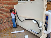 Children playing with a large, beige, weather-proof magnetic wall featuring movable ramps and rings on a brick patio.