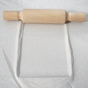 Wooden patterned rolling pins creating textured designs on clay and sand surfaces