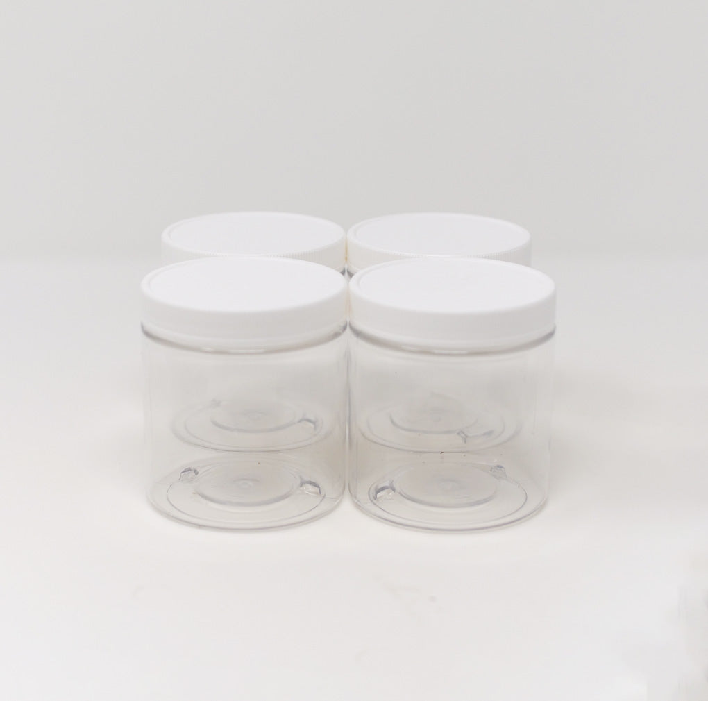 Set of four clear 8-oz plastic storage jars with white screw-on lids arranged in a square on a white background.