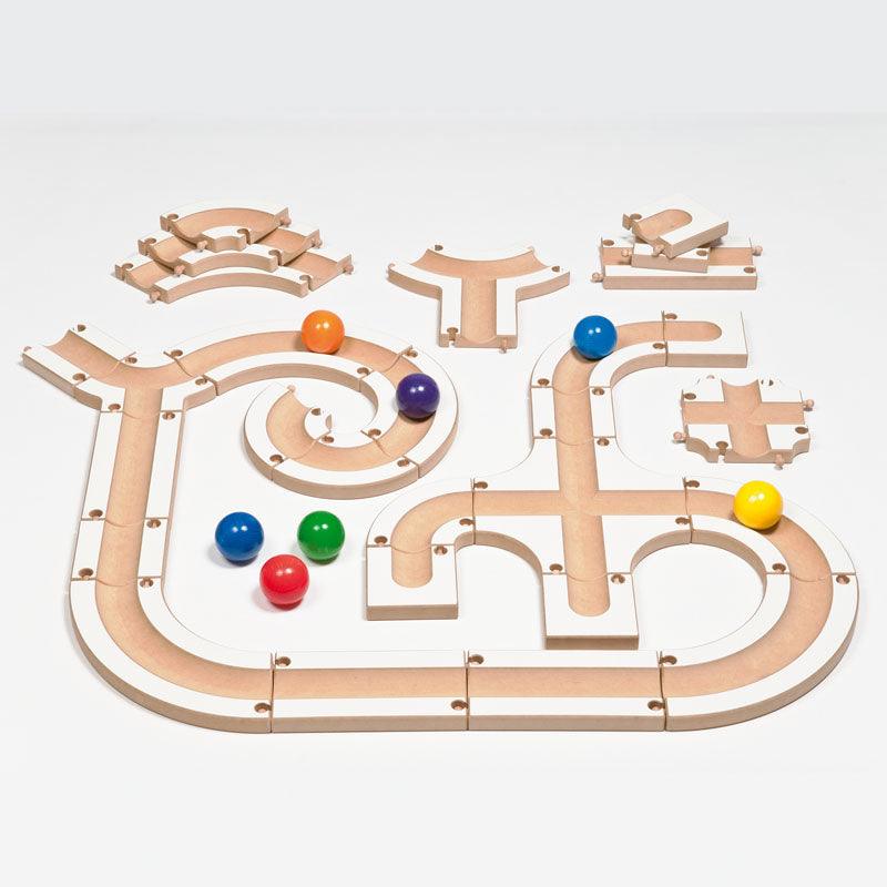 Modular wooden puzzle ball track with white and natural wood finish, featuring colorful spheres and various curved path segments.