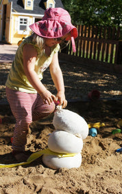 Children playing and building with flexible white sandbags in a classroom setting