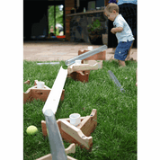Child playing with a STEM see-through pipe and wooden stand set on a grassy lawn for outdoor sand and water play.