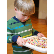 Child holding a white Sift & Sort screen filled with colorful sensory beads for size classification.