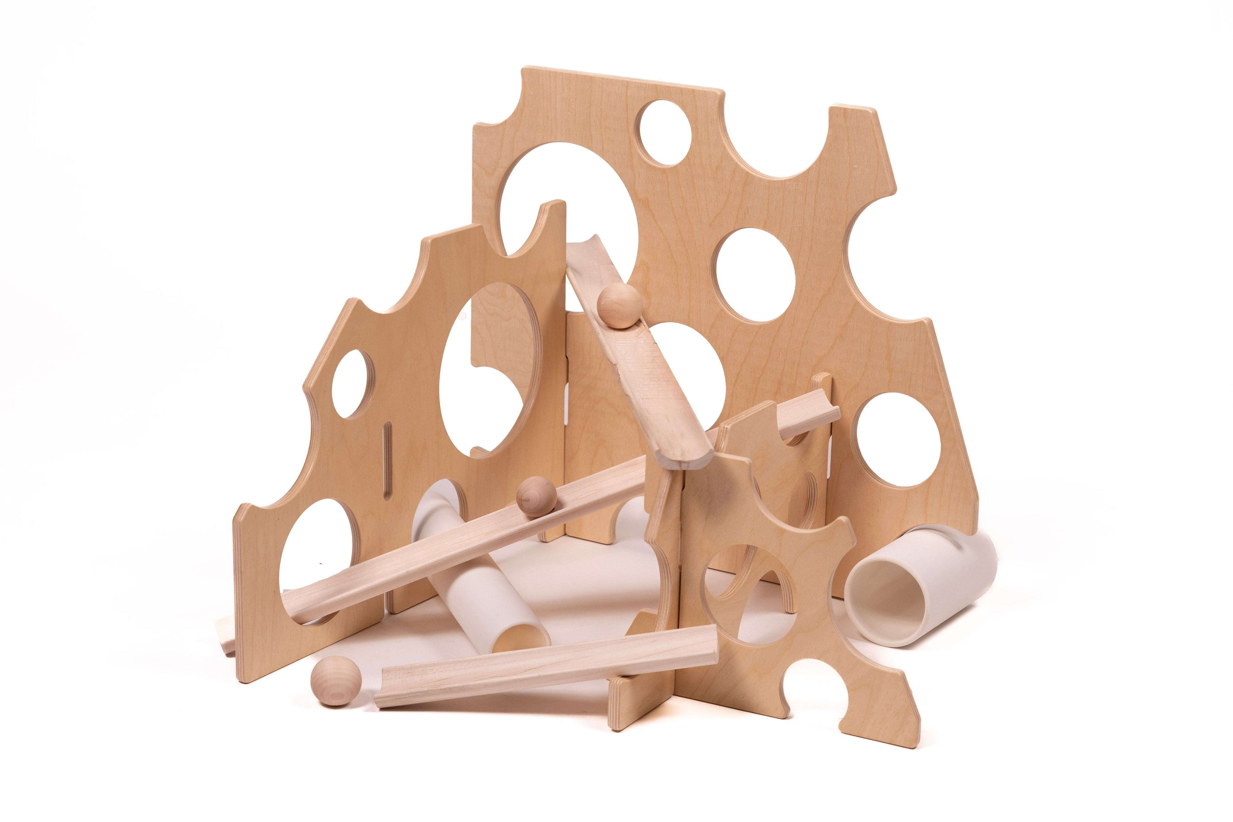 Swiss cheese-inspired wooden ramp stands with circular cutouts and marble tracks for STEM physics play.