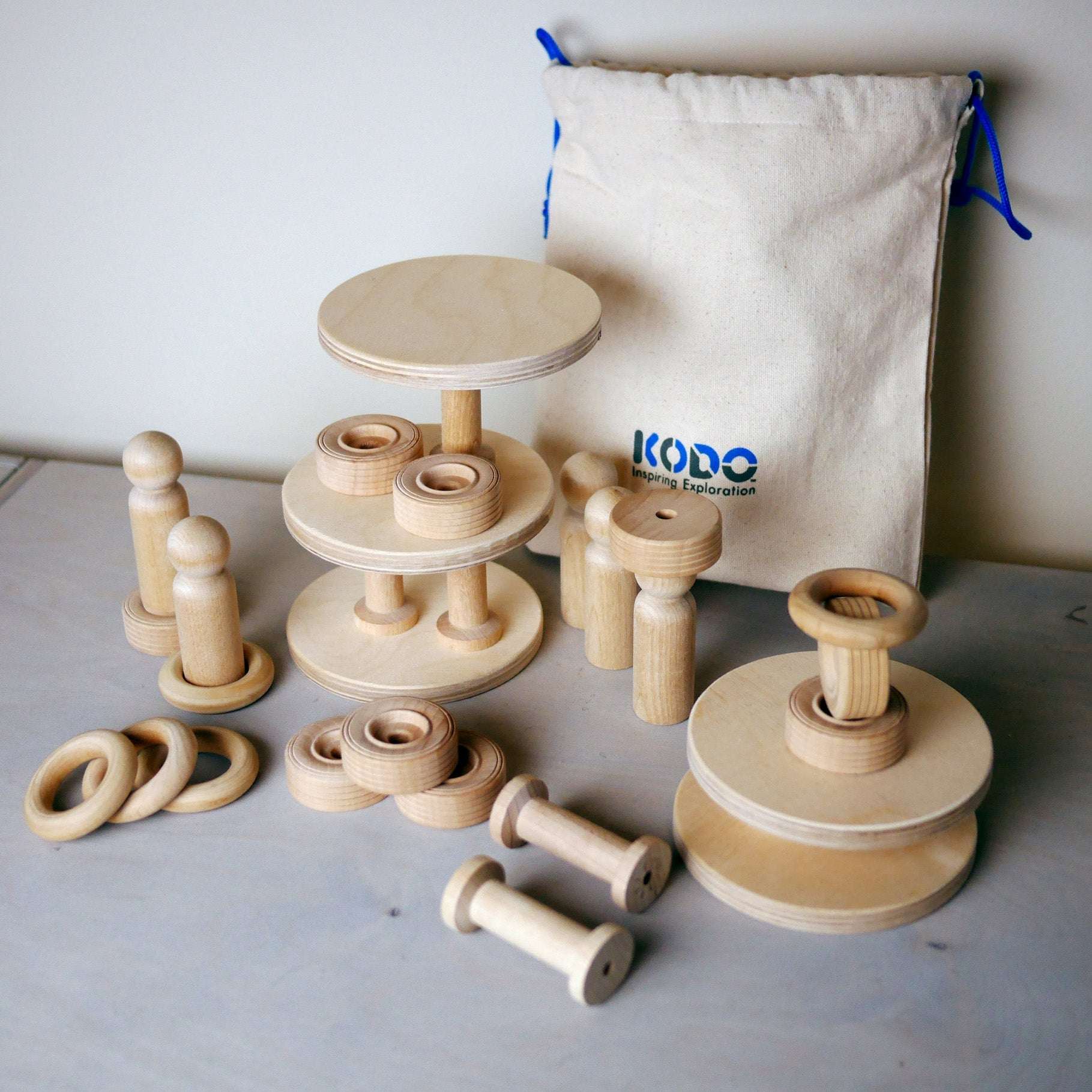 Set of 30 natural wooden building blocks, rings, and figures for toddler STEM play, including a Kodo canvas storage bag.