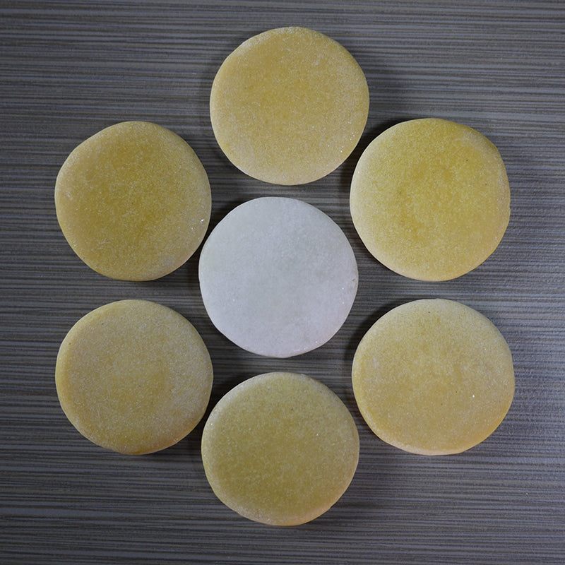 Smooth, round yellow and white counting stones made from a durable stone and resin mix arranged in a flower pattern.