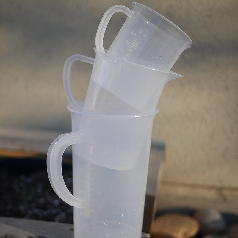 Three graduated, translucent polypropylene pitchers with handles stacked vertically for easy storage.