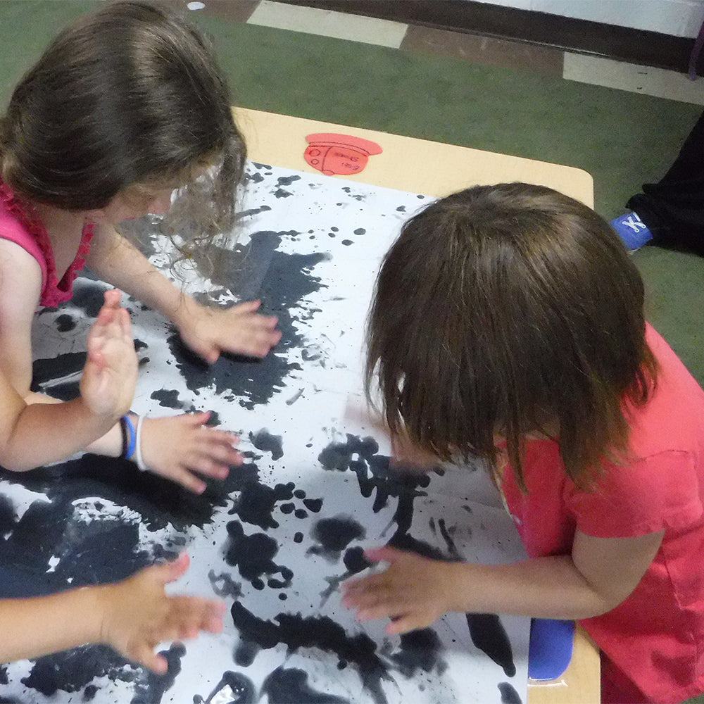 Kids painting on reusable Water Canvas that changes color with water