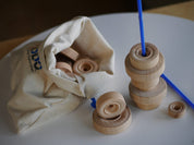 Natural wooden wheels in various sizes with a canvas storage bag and blue plastic rods for STEM play.