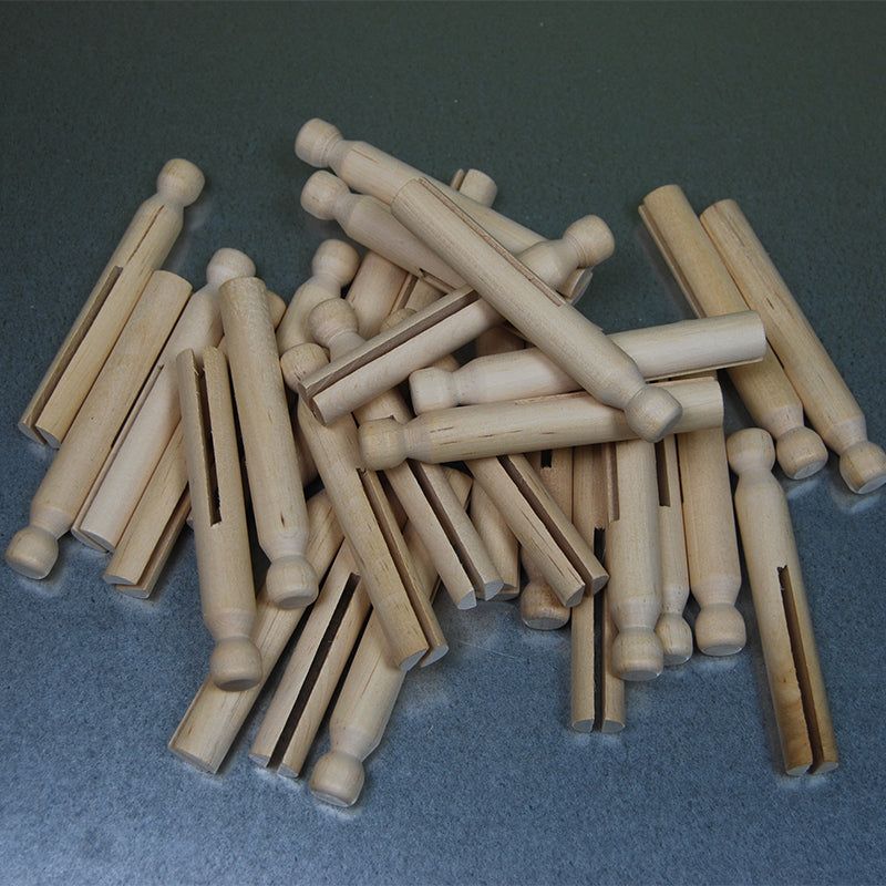 A pile of thirty natural light-colored wooden clothespins with a classic doll-pin design for open-ended play.